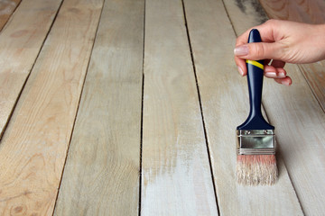 woman paints a new brush wooden table