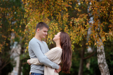 Fototapeta premium happy young couple embracing outdoor in the autumn park