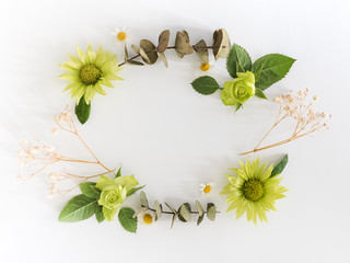 Frame  with  roses, green flowers and leaves on white background. 