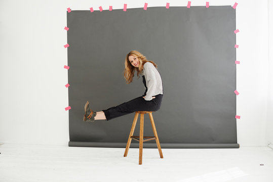 Woman on stool in front of photographers backdrop