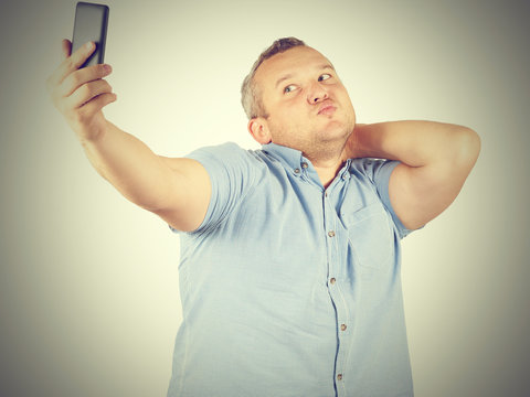 Funny picture of  plump man  businessman doing selfie.