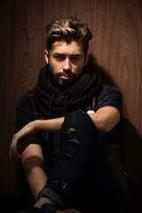 Fototapeta premium beautiful fashionable man against wooden wall