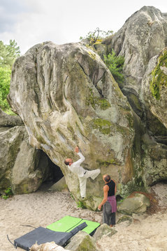 Mann nimmt schwierigen Boulderfelsen in Angriff