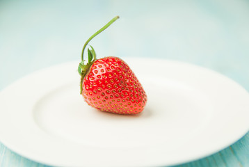 Ripe strawberry fruit on a white plate