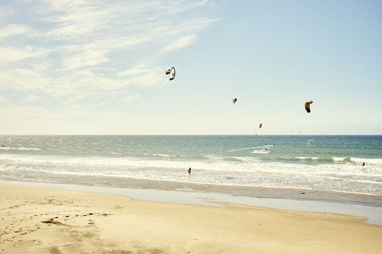 Distant view of small group of kitesurfers, Pacifica, California, USA