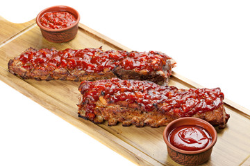 Barbecued ribs with sauce on cutting board.
