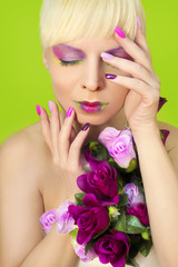 Fototapeta premium Colorful lilac manicure and lips on a girl with roses on a green background.