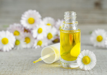 Small bottle of cosmetic chamomile oil for nail and cuticle care - obrazy, fototapety, plakaty