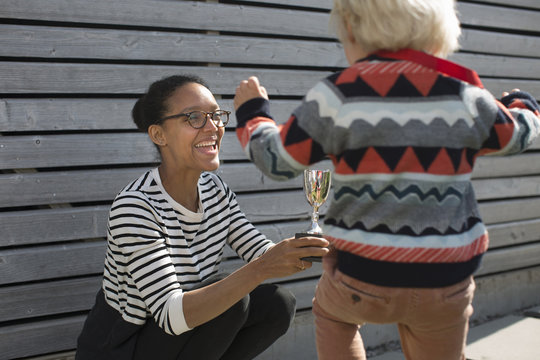 Mother giving son trophy