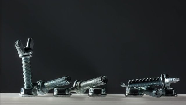 row of screw with caps wrenching on black background 