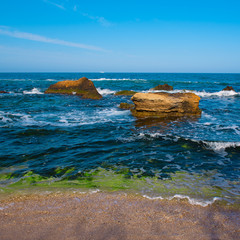 Sea coast with rocks, blue water and clear sky, natural seasonal summer background