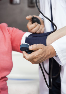 Cropped Image Of Doctor Checking Blood Pressure Of Senior Patien