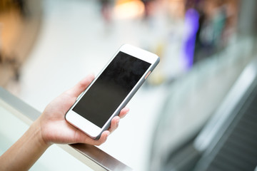 Woman hold with mobile phone inside shopping mall