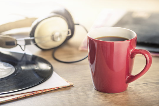 Still life of black coffee, headphones and vinyl record