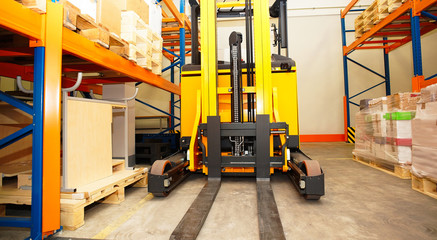 Fototapeta na wymiar Forklift, shelves and racks with pallets in distribution warehou