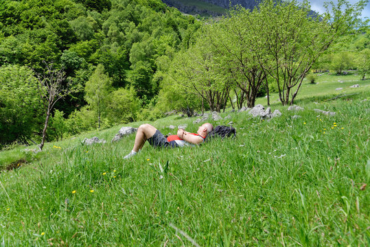 Mature male hiker lying in meadow taking a break