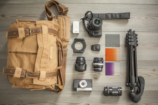 Camera equipment and camera bag arranged on table, overhead view