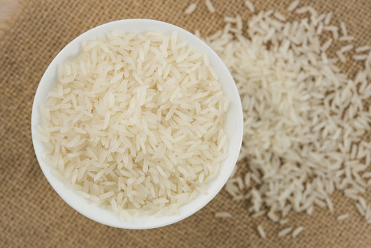 rice grain in white bowl on table.
