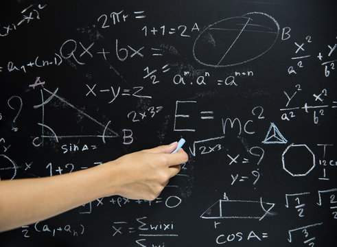 Teacher Hand drawn mathematics on chalkboard.
