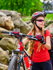 Bikes bicyclist girl. Girl rides bicycle into mountains. Girl on bicycle in mountaineering  . Mountaineering  is good for health. Cyclist looking away.