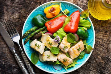 Fish fillets with vegetables on wooden background
