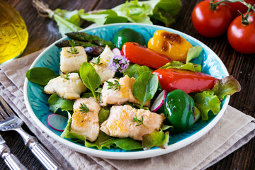 Fish fillets with vegetables on wooden background