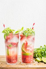 Strawberry mojito summer cocktails with mint and lime in tall glasses