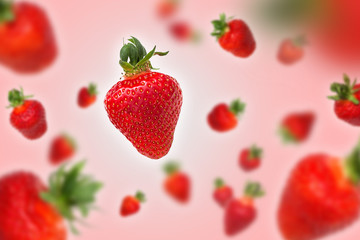 Flying strawberries on pink background