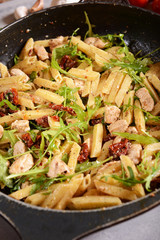 Penne pasta with chicken, dried tomatoes and ruckola