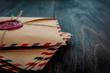 Old letters envelopes with a wax magic stamp triquetra on wooden table