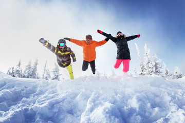 Group of three friends jumps like superhero into snowdrift. Sheregesh resort, Siberia Russia