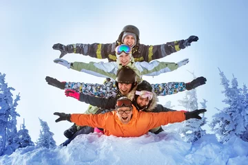 Papier Peint photo Sports dhiver Group of happy friends having fun lying on snowdrift. Sheregesh resort, Siberia, Russia