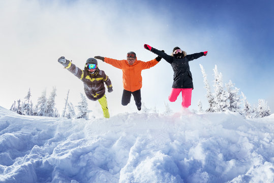 Group of three friends jumps like superhero into snowdrift. Sheregesh resort, Siberia Russia