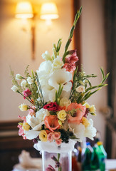 Flowers, wine glasses, napkins and salad on the table for the banquet.