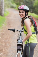 Naklejka premium Cheerful woman with bike standing on footpath