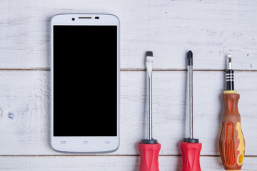 smartphone and equipment repair on the white wooden background.