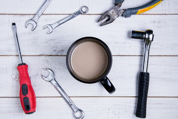 Coffee cup and equipment repair on the white wooden background
