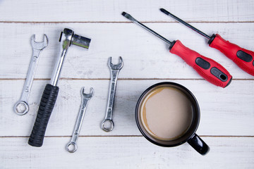 Coffee cup and equipment repair on the white wooden background