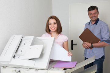 Businessman and woman using a copy machine