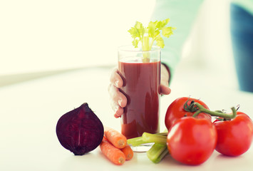 close up of woman hands with juice and vegetables