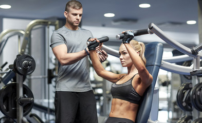 Fototapeta na wymiar man and woman flexing muscles on gym machine