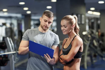 Rollo smiling young woman with personal trainer in gym © Syda Productions
