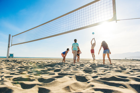 Group of friends playing volleyball on beach