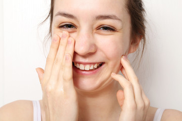 Nastolatka myje twarz na białym tle  - obrazy, fototapety, plakaty