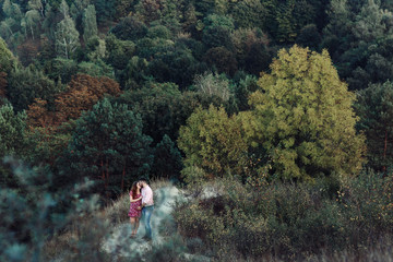 Fototapeta premium Beautiful couple, husband & wife posing & kissing in forest, lan