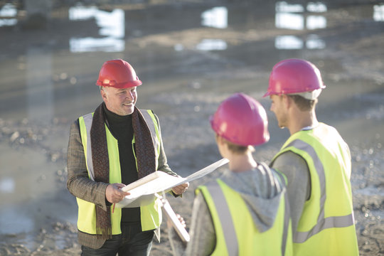 Architect meeting with builders on construction site