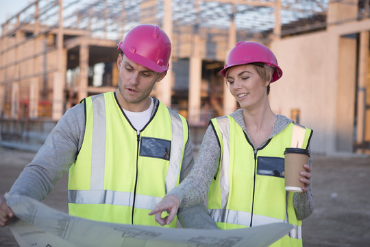 Architect planning together while holding blueprint