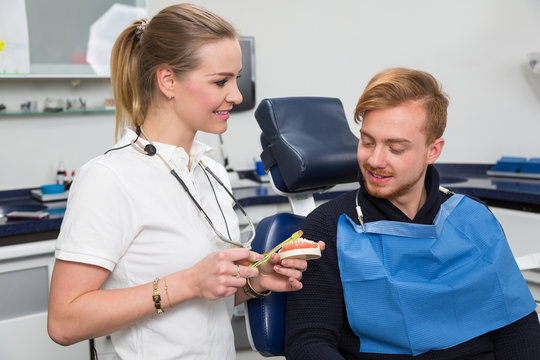 Dentist advising a patient about cleaning teeth properly