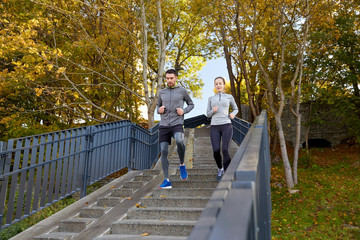 Fototapeta premium happy couple running downstairs in city