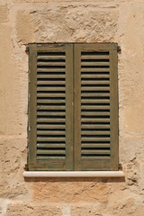 Fototapeta na wymiar window with vintage shutter in stone wall